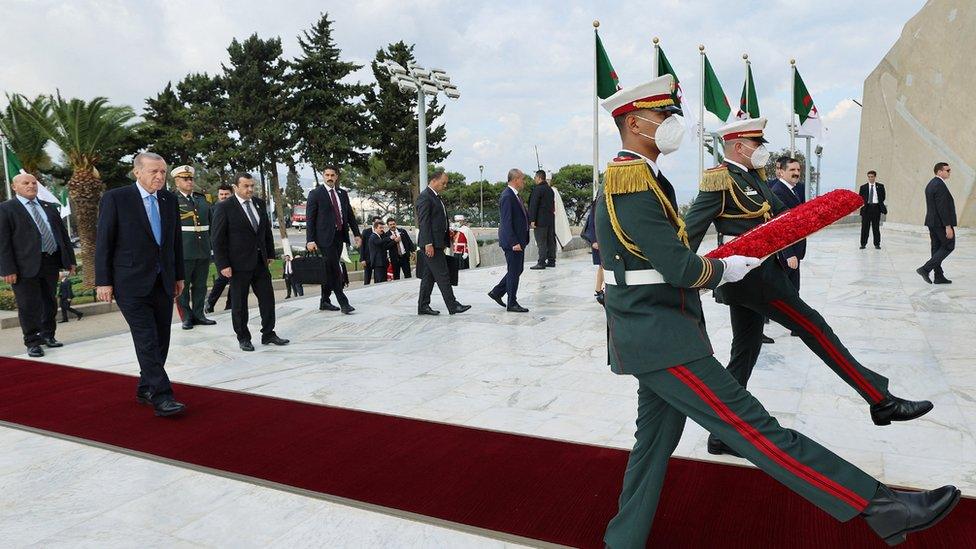 Turkey's President Tayyip Erdogan, with soldiers holding a wreath in front