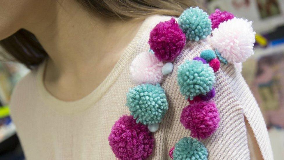 Pom poms on the shoulder of a dress