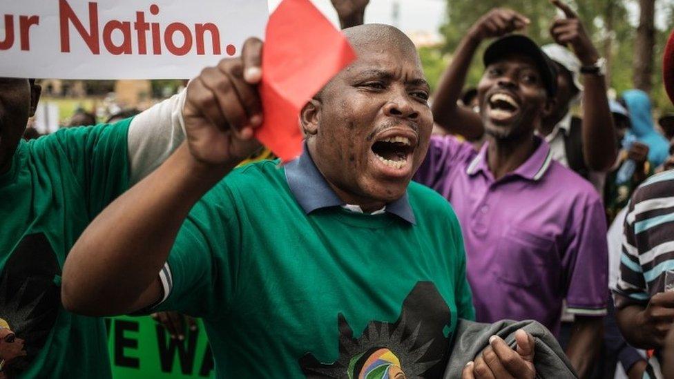 South Africans shout slogans as they take part in a protest for the resignation of South African President Jacob Zuma