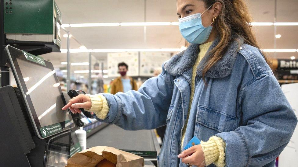 A woman wearing a face covering in a supermarket