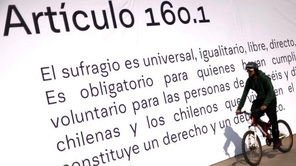 A person cycles past a banner showing item number 160.1 of the proposed new Chilean constitution placed in a public area ahead of the September 4th constitutional referendum, in Santiago, Chile August 23, 2022.