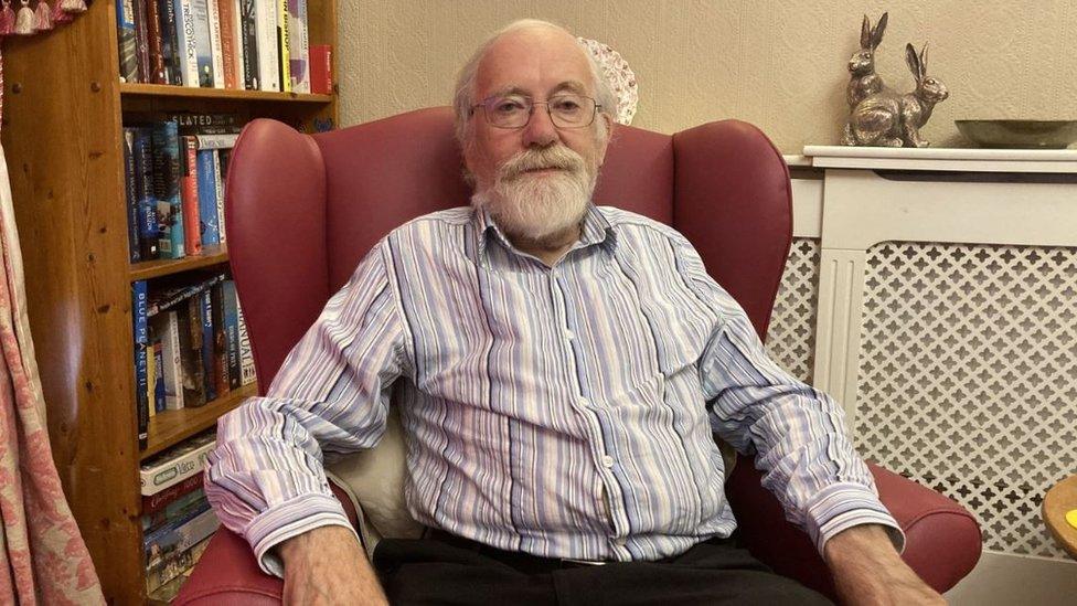 Peter Coombs sitting in a red chair