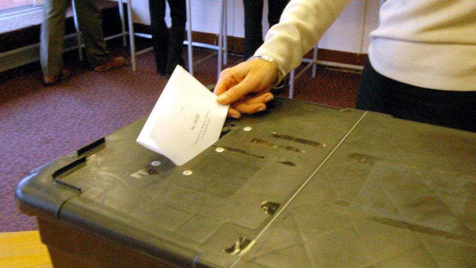 Woman voting at ballot box