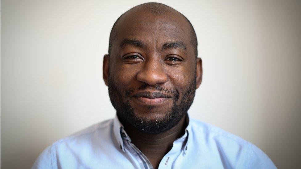 Headshot of Poku Osei smiling at the camera