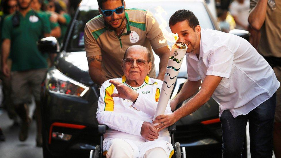 Plastic surgeon Ivo Pitanguy carries the Olympic torch as it makes its way to Maracana Stadium for the opening ceremony of the Rio 2016 Olympic Games, in Rio de Janeiro, 5 August