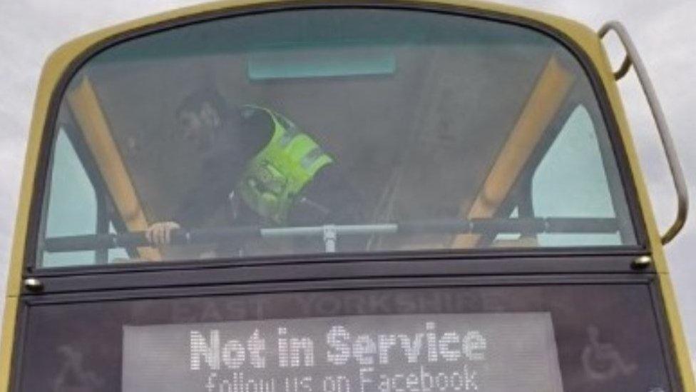 Police officer on the top floor of a double-decker bus