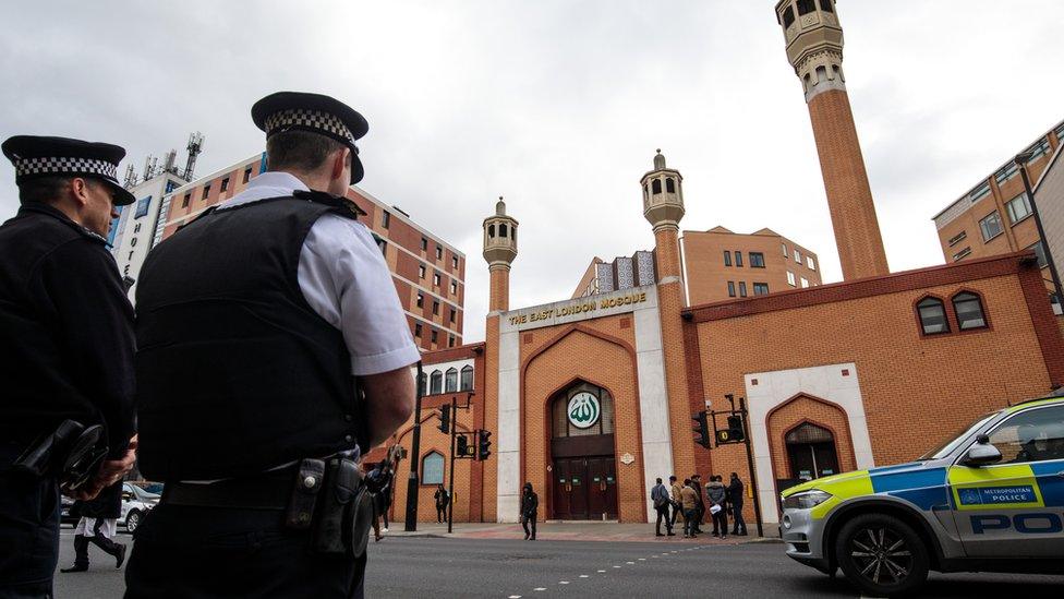 Police officers stand on patrol outside the East London Mosque