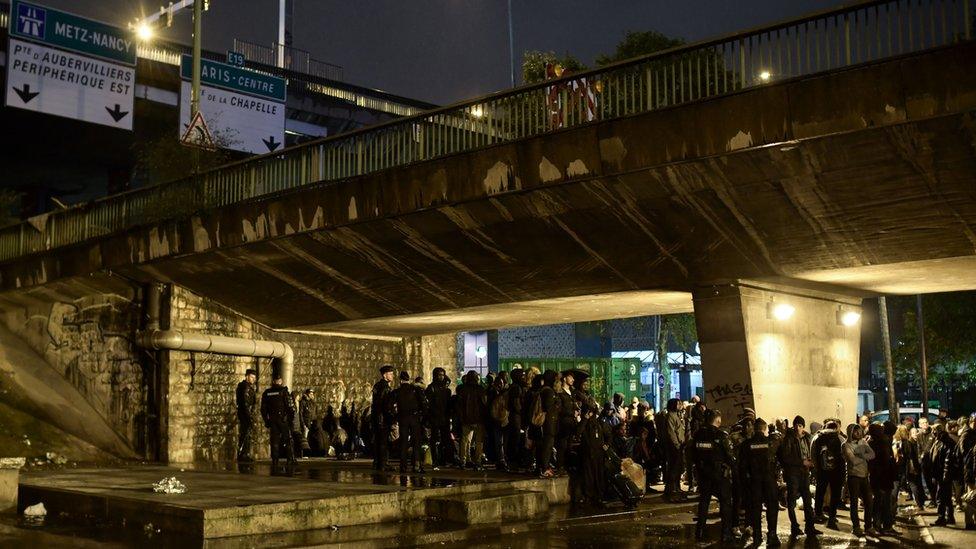 Migrants are gathered by French police before being evacuated from their makeshift camp in Paris on November 7, 2019