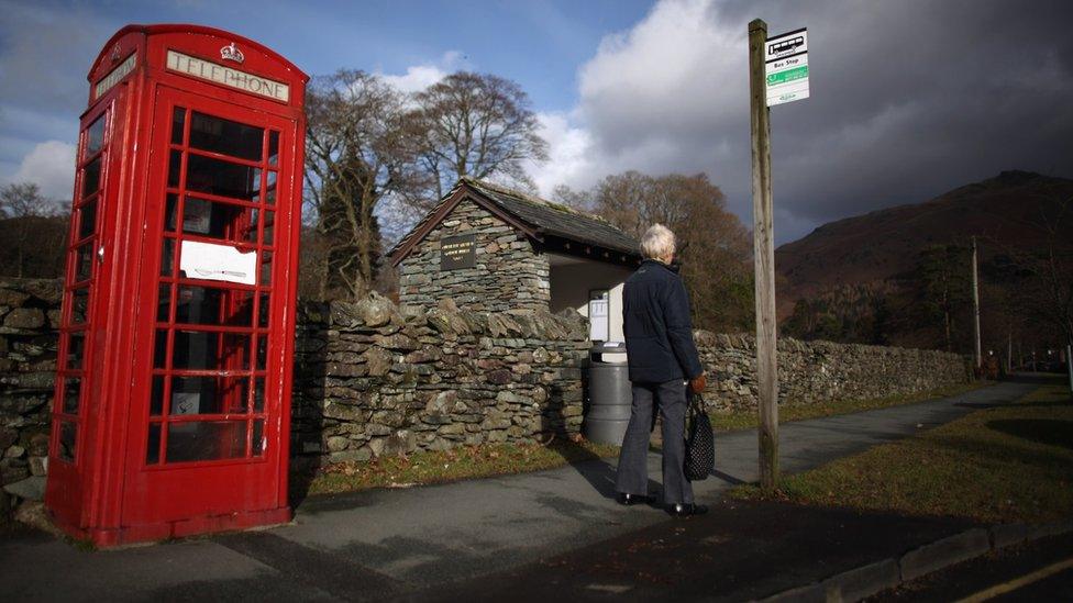 Woman waiting at bus stop in countryside