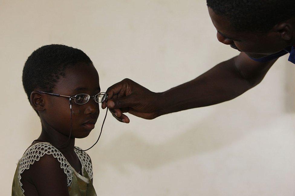 A child tries on a new pair of glasses in Togo