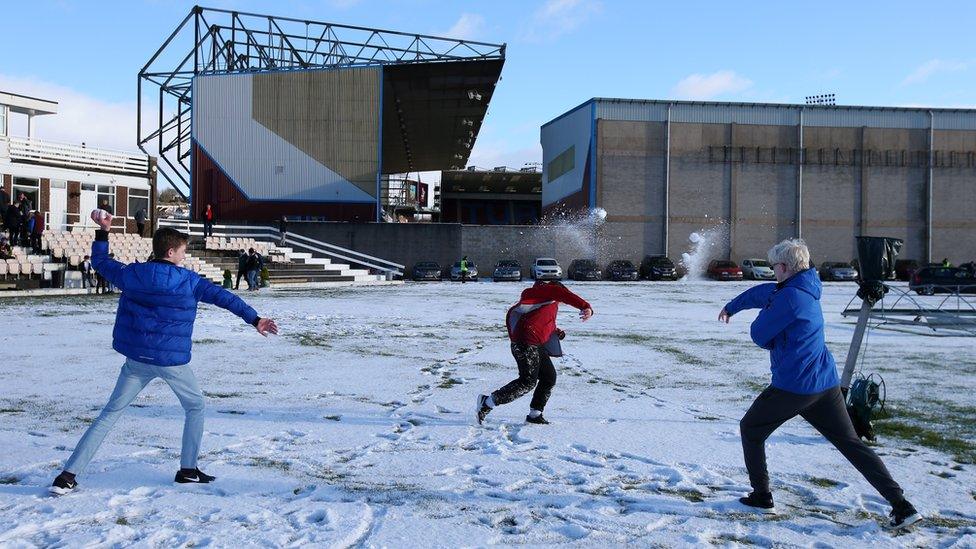 Fans play in the snow outside Turf Moor stadium ahead of Burnley and Southampton's Premier League game