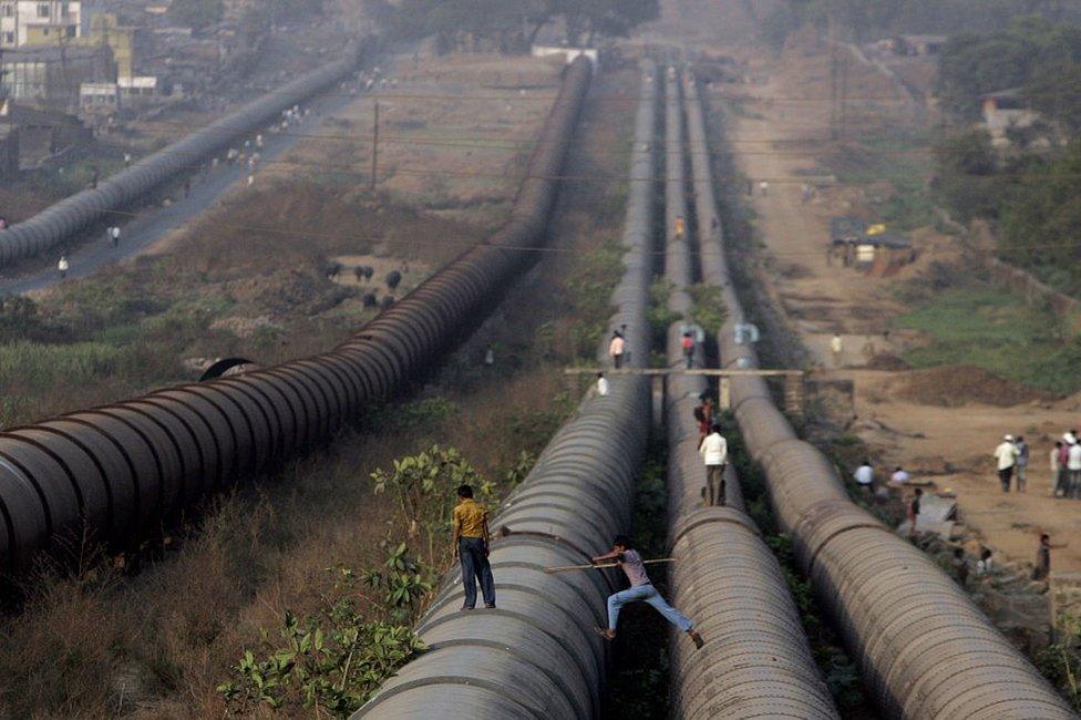 Locals walk on the Tansa water pipeline