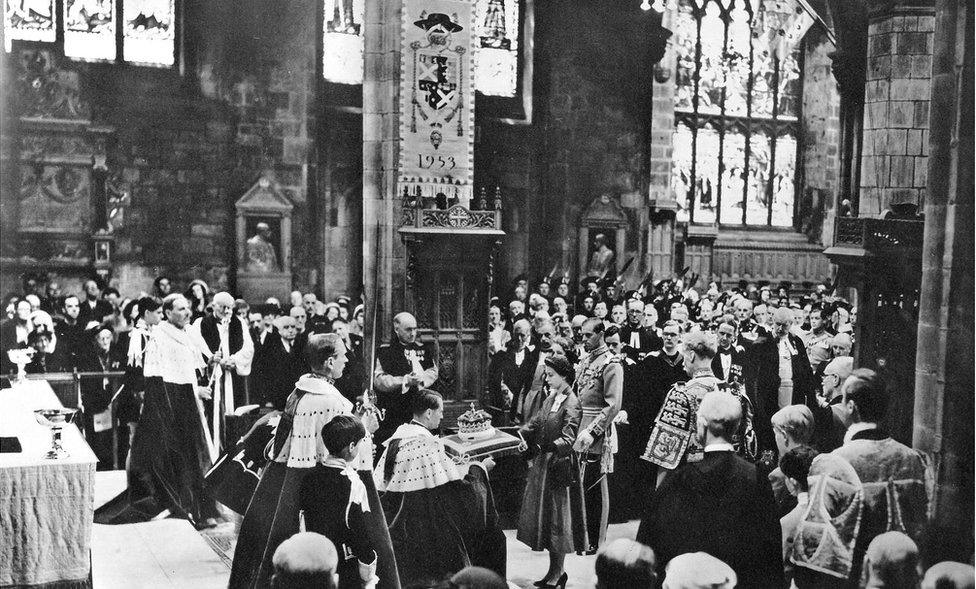 Queen Elizabeth is presented with the Crown of Scotland on a velvet cushion inside St Giles Cathedral