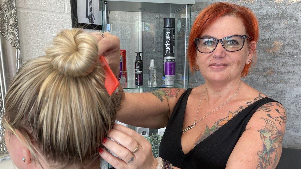 Emma Ashton, from Stewartby, Bedfordshire working on a woman's hair in her salon