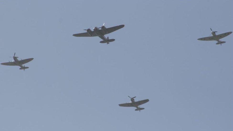 Four planes flying in a hazy blue sky