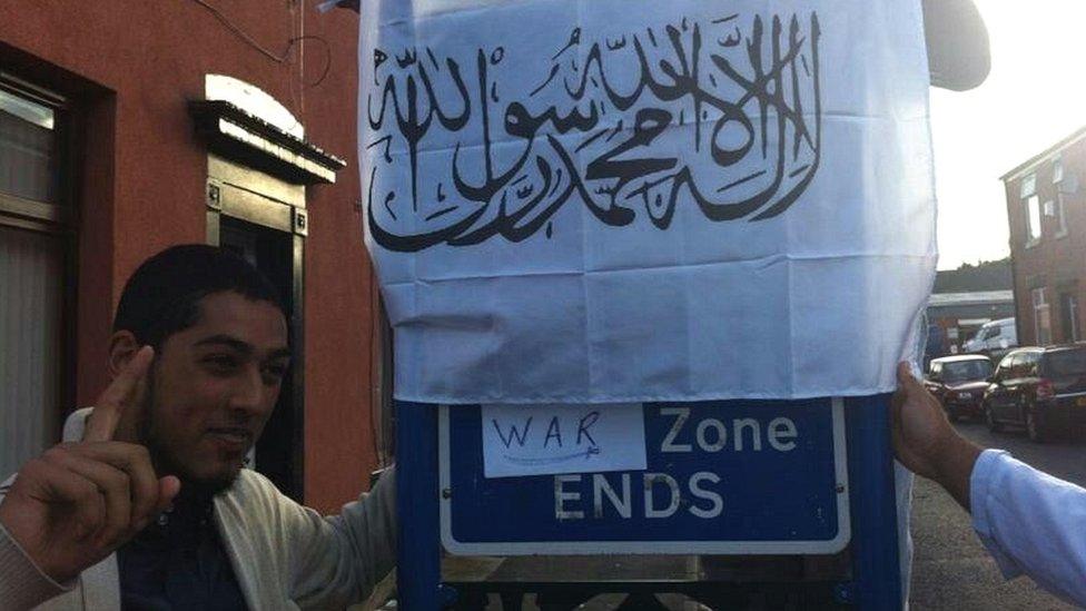 Syeedy with Arabic banner over traffic sign