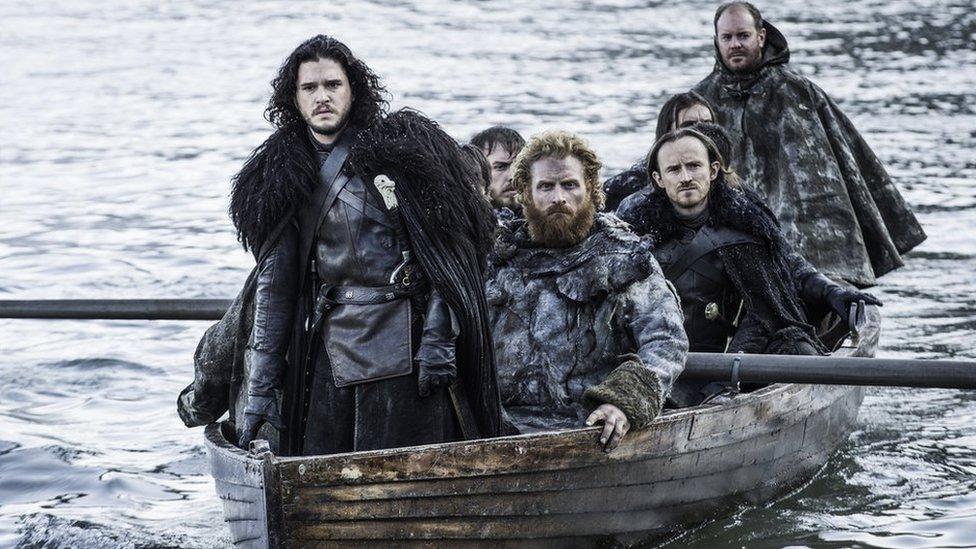 Jon Snow and other characters from Game Of Thrones travelling in a boat