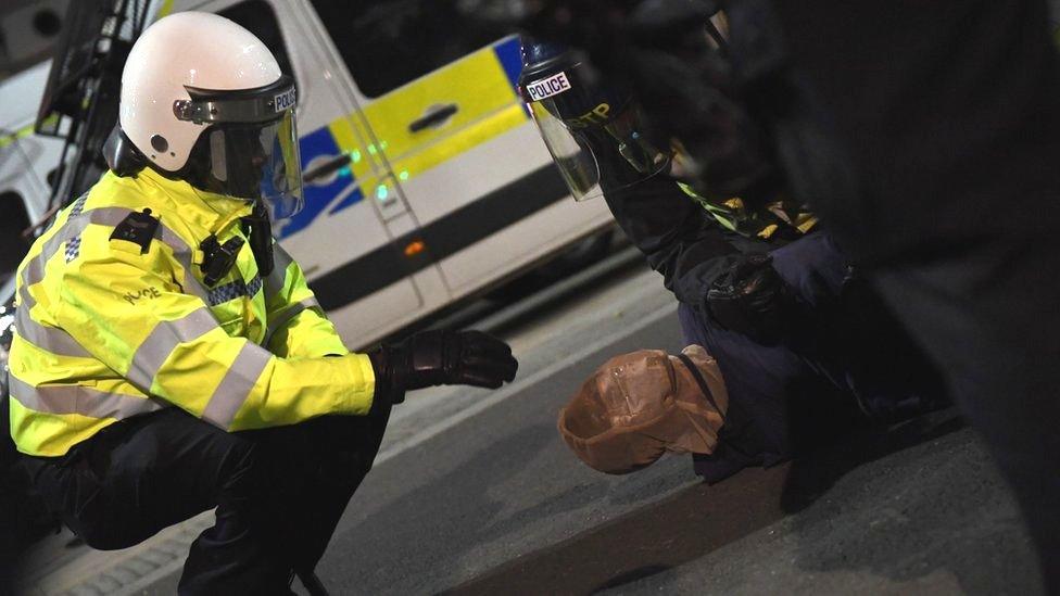 A protester is placed in a spit hood as he is restrained by police during a Black Lives Matter protest in London in June 2020