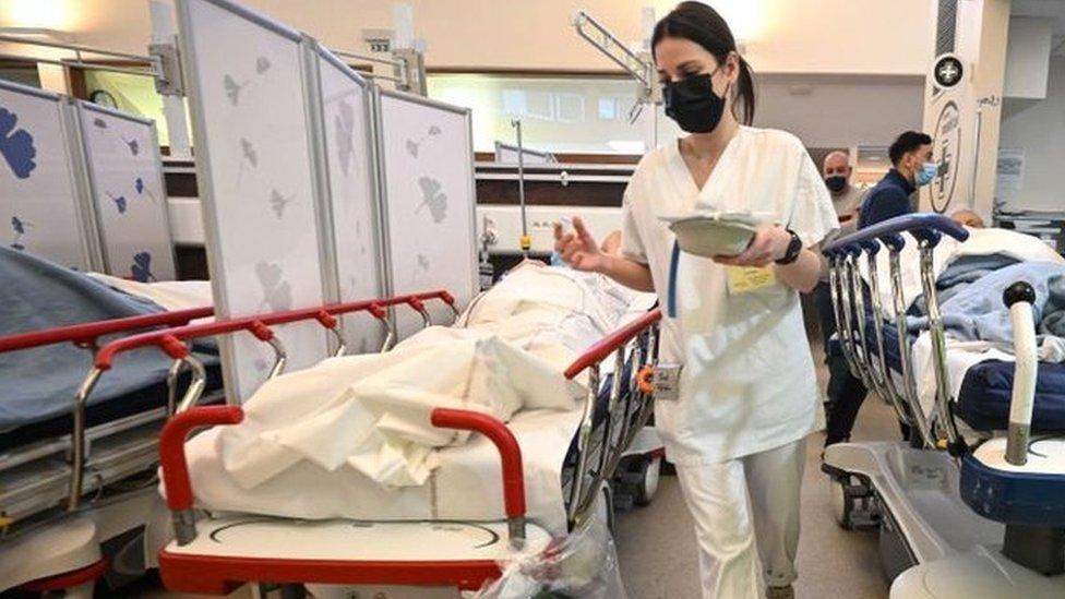 A nurse walks between two patients' beds in the middle of the emergency room of the Hautepierre hospital, in Strasbourg, eastern France