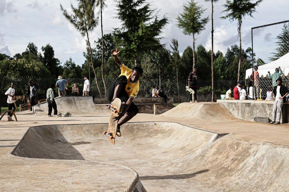 A skateboarder performs a trick at a skate park.