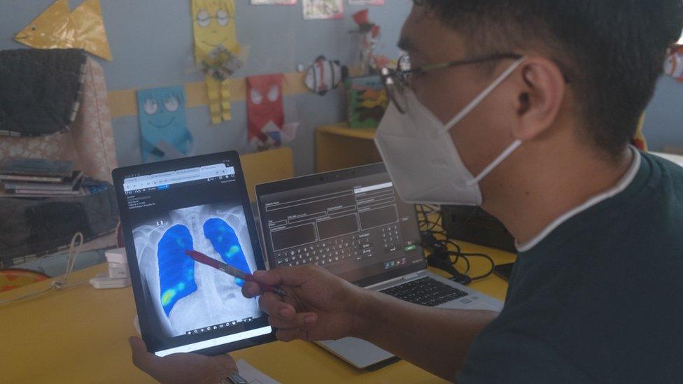 A radiologist examines a digital X-ray, taken with an ultraportable device