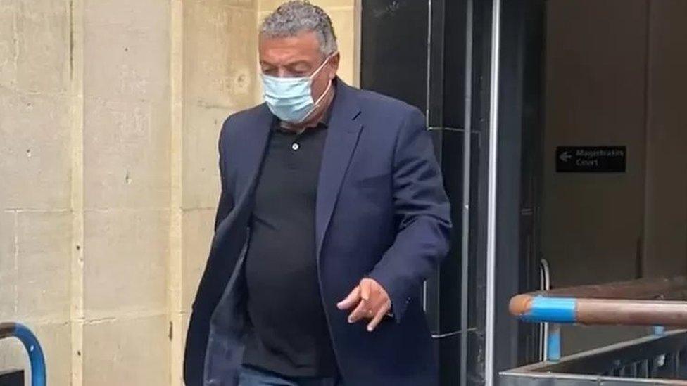 Man wearing a mask leaving court