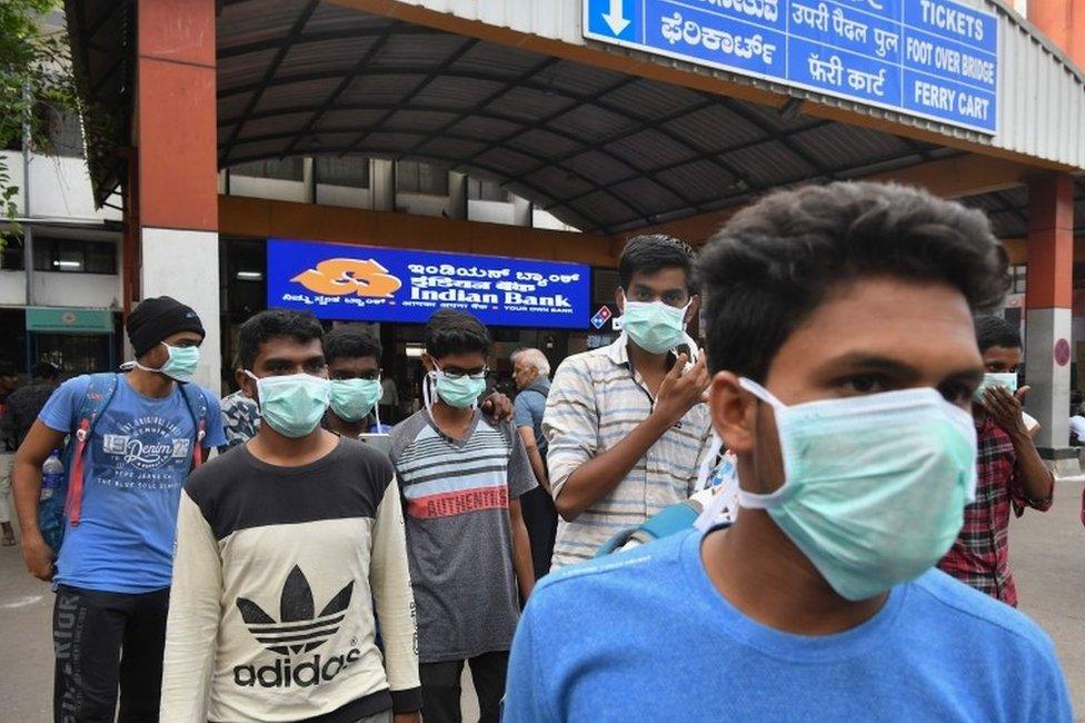 Young tourists wear facemasks as a preventive measure against the spread of the COVID-19 coronavirus outbreak at the Bangalore City Railway Station, on March 4, 2020.