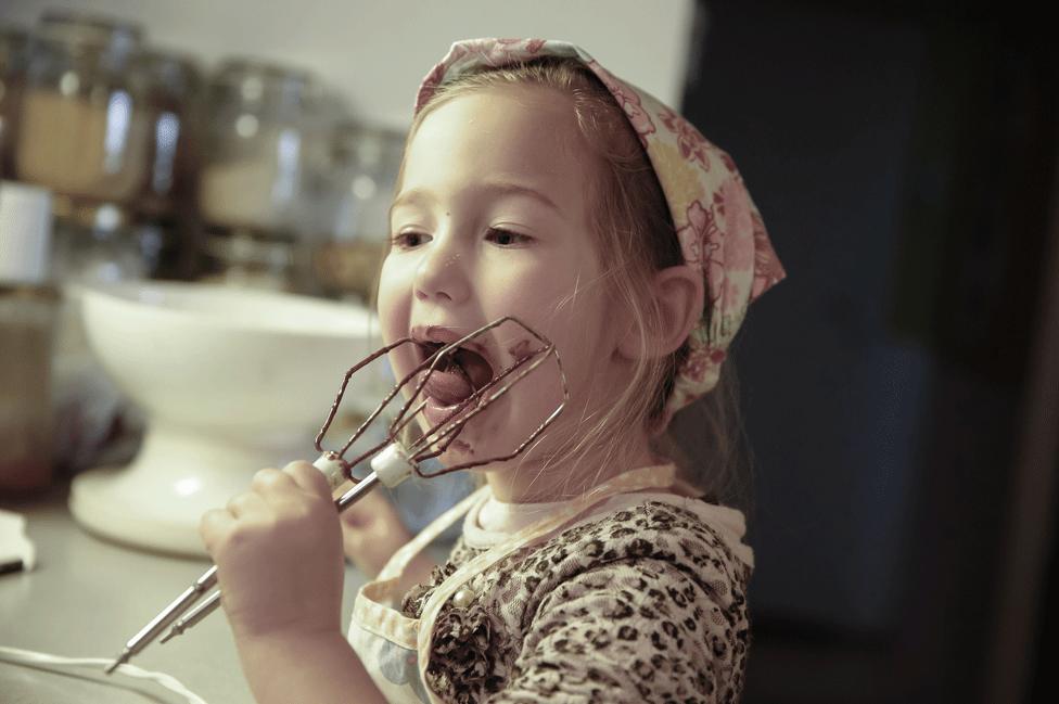 Girl eating cake mixture