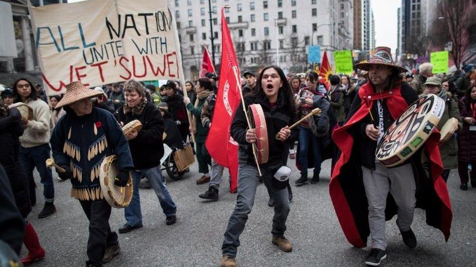 Alex Spence beats a drum and sings during a march in support of pipeline protesters in Vancouver