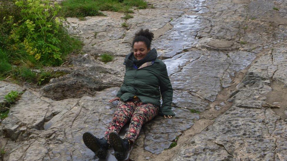 Elsie Harp from OTR slides down a well known rock slide in Bristol near the Clifton Suspension Bridge