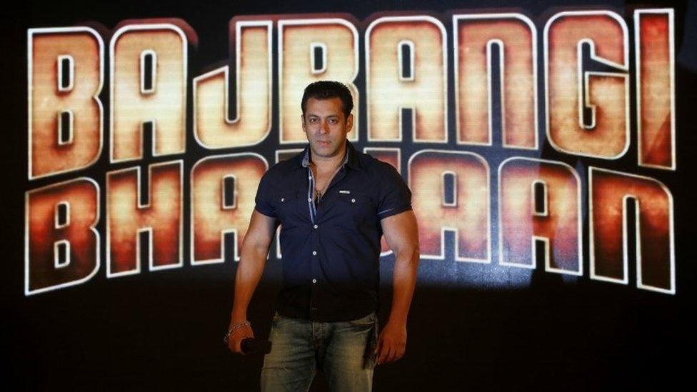 Salman Khan in front of a poster for the film Bajrangi Bhaijaan