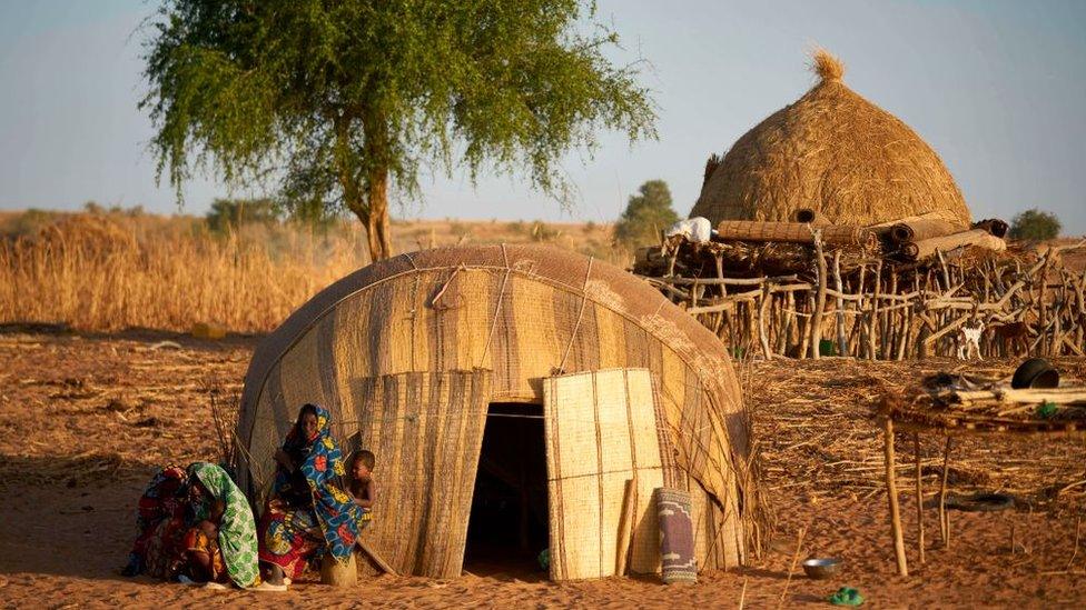 A family sits in front of their home in the Soum region in northern Burkina Faso