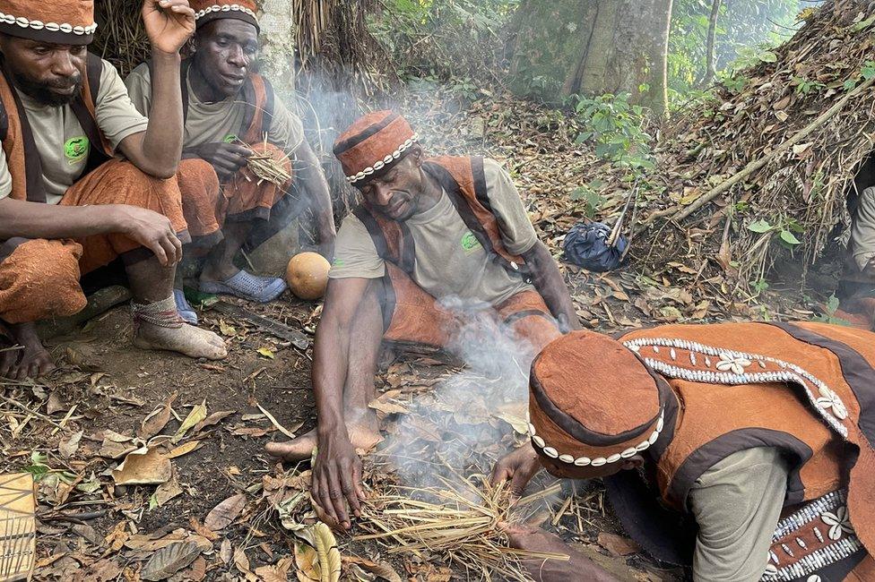 Men breathing on a fire