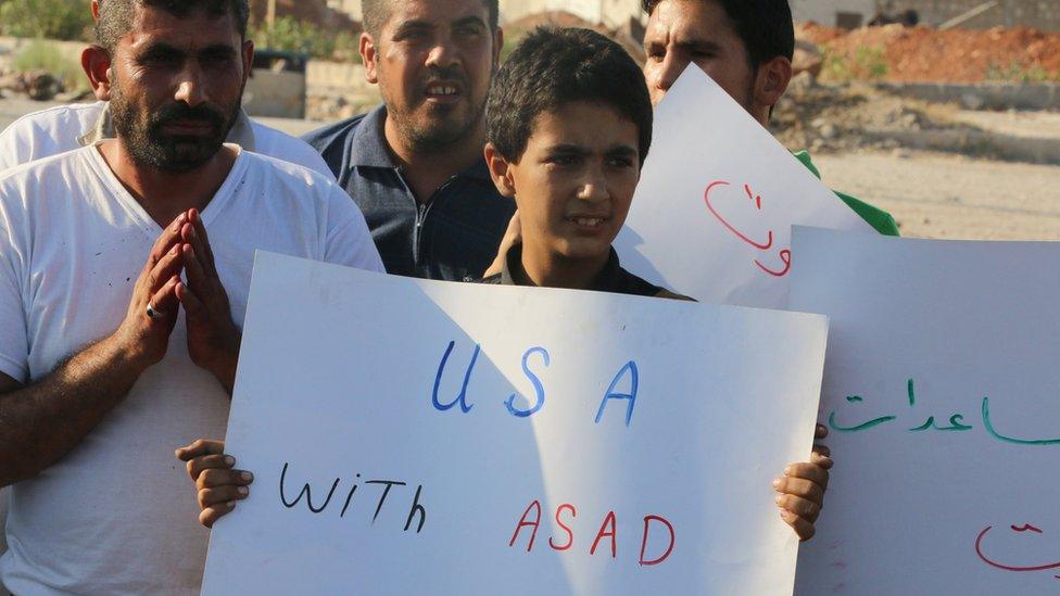 A boy carries a placard during a demonstration against forces loyal to Syria"s president Bashar al-Assad and calling for aid to reach Aleppo near Castello road in Aleppo, Syria, September 14, 2016