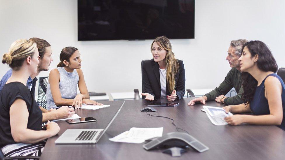 Businessmen and women meeting in conference room