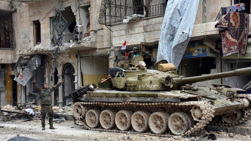 Syrian army soldiers make victory signs in the Sukkari neighbourhood, east Aleppo, Syria (23 December 2016)