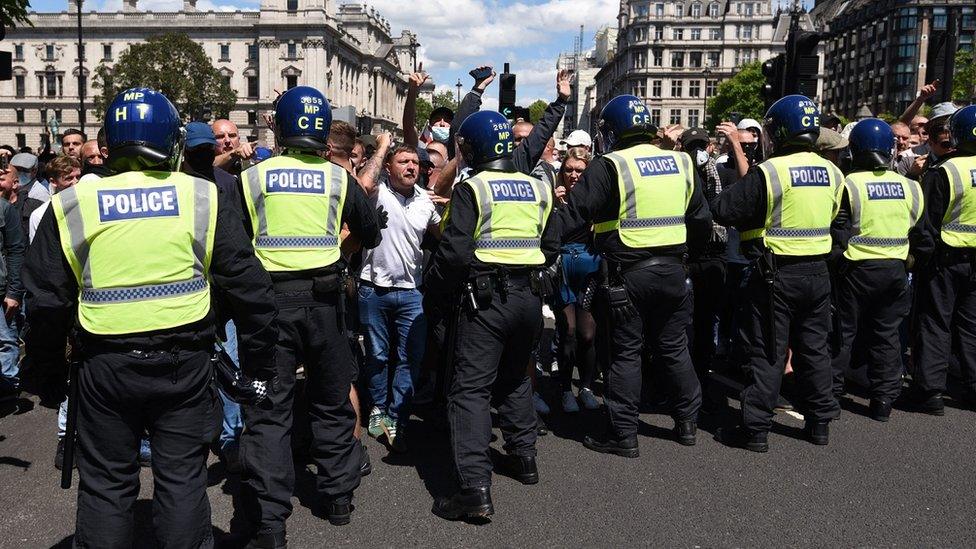 Police form a barrier in front of protesters in Parliament square