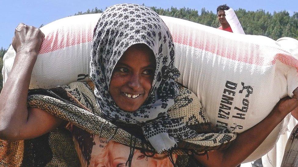 A woman carrying a sack of wheat flour in Chena, Amhara region