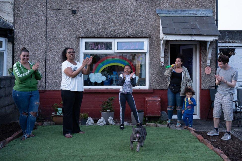 A family claps to show their appreciation for NHS and other key workers on 9 April 2020 in Cardiff, Wales