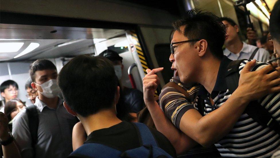 An angry stranded passenger argues with Anti-extradition bill protesters