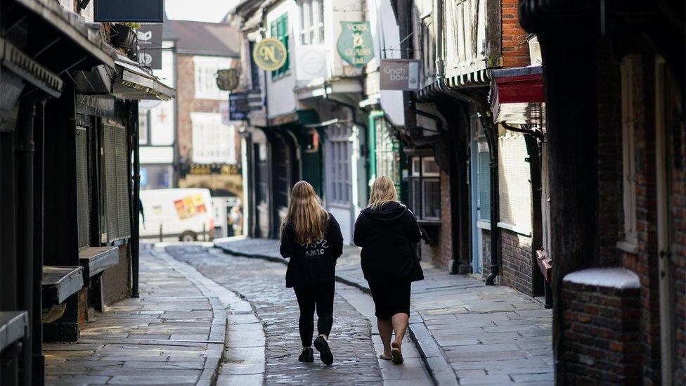 Two people walking down the Shambles