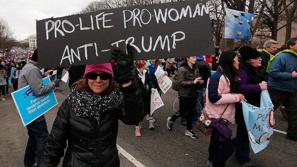 Woman with a 'pro-life, pro-woman, anti-Trump' placard