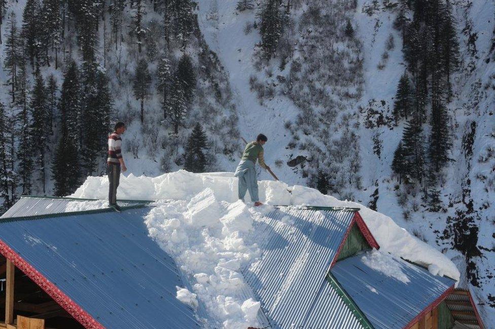 Villagers clear snow from roofs in Neelum valley