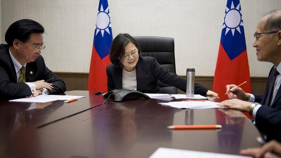 Photo released by Taiwan Presidential Office Saturday, Dec. 3, 2016, Taiwan's President Tsai Ing-wen, center, flanked by National Security Council Secretary-General Joseph Wu, left, and Foreign Minister David Lee, speaks with U.S. President-elect Donald Trump through a speaker phone in Taipei, Taiwan.