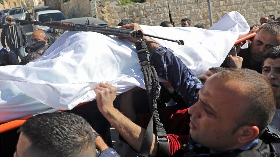 Palestinian police carry the body of officer Tareq Badwan out of a hospital in Jenin (6 February 2020)