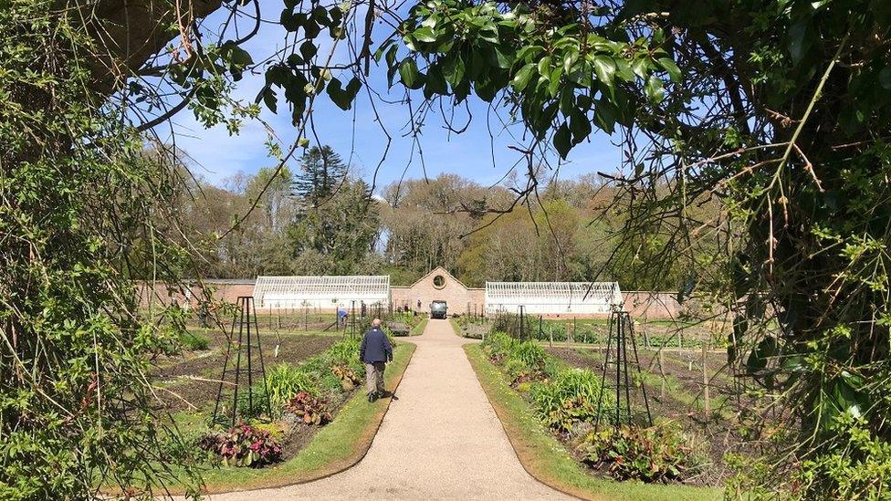 Florence Court gardens and a worker walking on the path