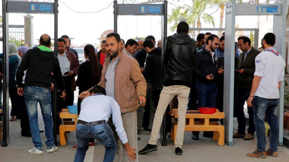 Mourners go through security checks outside the Monastery of St Mina in Alexandria