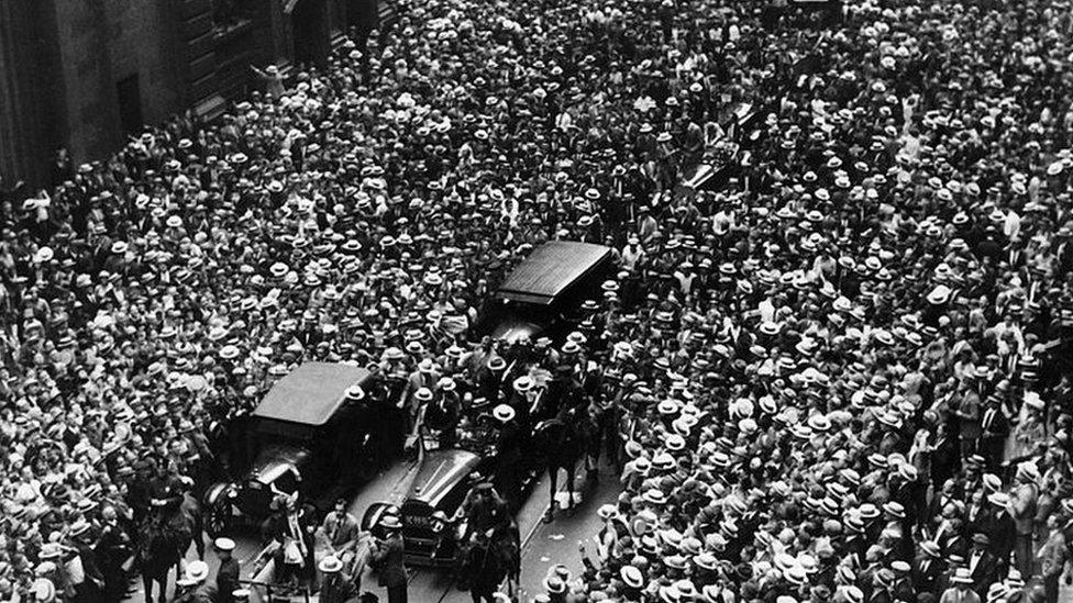 Photo shows a general view of the Ederle welcoming procession coming up lower Broadway, the street jammed with humanity from side to side, while Gertrude Ederle, waves her greeting from the first automobile in the procession. (Photo by George Rinhart/Corbis via Getty Images)