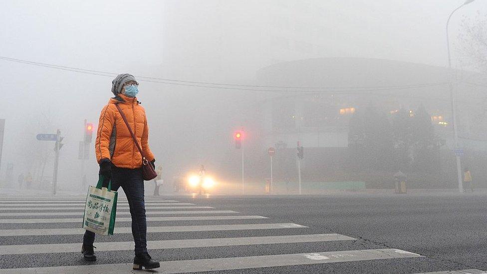 Woman walking through smog in China