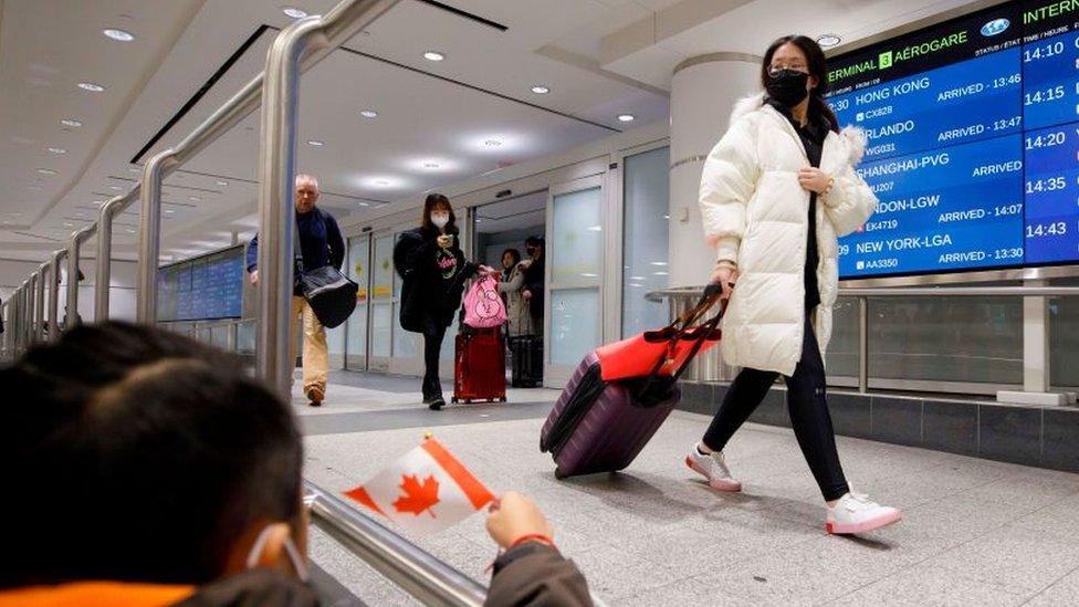 Travellers are seen wearing masks at the international arrivals area at the Toronto Pearson Airport in Toronto, Canada, January 26, 2020